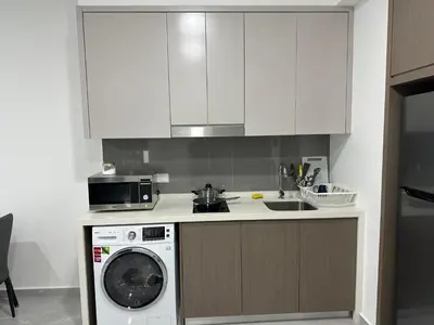 a kitchen with a washing machine and a microwave at Agile Residence Bukit Bintang TRX By SweetHome in Kuala Lumpur