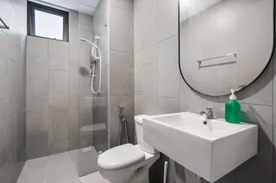 a bathroom with a sink and a toilet and a mirror at 4BR Modish Room MVertica Near MRT by RumaBnB in Kuala Lumpur