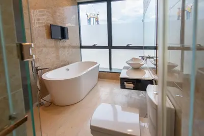 a bathroom with a tub and a toilet and a window at 1-6pax Dorsett KL 3mins to Pavilion Infinity Pool in Kuala Lumpur