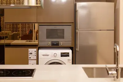 a kitchen with a washing machine and a refrigerator at 1-6pax Dorsett KL 3mins to Pavilion Infinity Pool in Kuala Lumpur