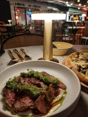 a plate of meat on a table with a pizza at Spacious 4BR condo near KLCC - Travel with MRT in Kuala Lumpur