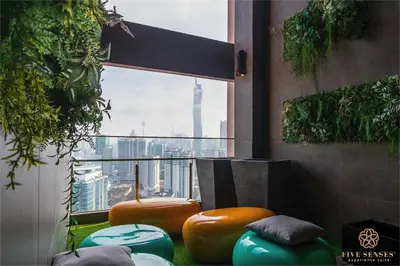 a room with orange and blue ottools in front of a window at Riveria Premium Kuala Lumpur, Roam in Kuala Lumpur