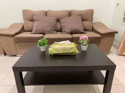 a living room with a couch and a table with flowers at Ampang 4-5 pax in Ampang Point in Ampang