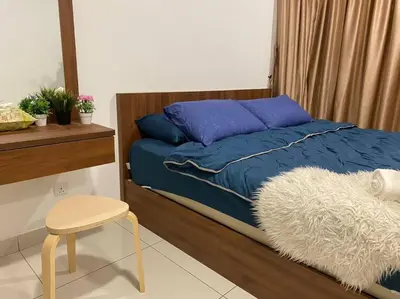 a bedroom with a blue bed with a chair and a table at Ampang 4-5 pax in Ampang Point in Ampang