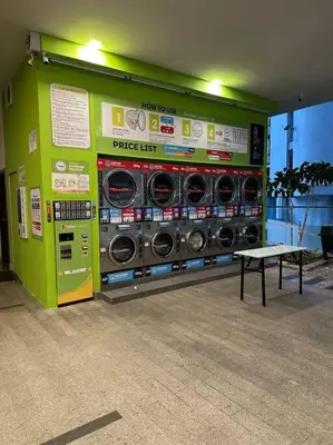 a green wall with washing machines in a room at 2br 2ba in the heart of KL, Regalia Residence in Kuala Lumpur