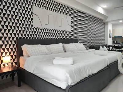 a large bed in a bedroom with a black and white wall at Vivo Soho Suites by Luvit Stay in Kuala Lumpur