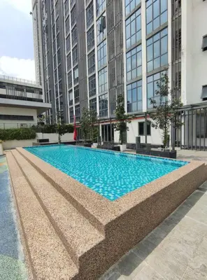 a large swimming pool in a building with tall buildings at Vivo Soho Suites by Luvit Stay in Kuala Lumpur
