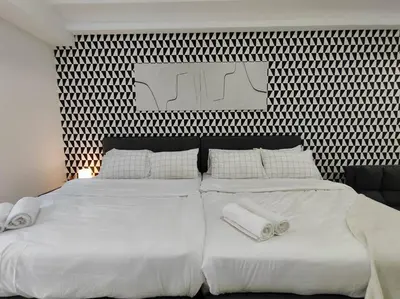 a bedroom with two beds with white sheets and pillows at Vivo Soho Suites by Luvit Stay in Kuala Lumpur