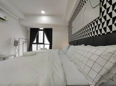 a bedroom with a large white bed and a window at Vivo Soho Suites by Luvit Stay in Kuala Lumpur