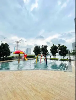 a pool with slides and an umbrella in a park at M Vertica By Seroja Coliving in Kuala Lumpur