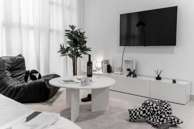 a white living room with a white table and a chair at Trion KL -2BR, 2-5pax, near KLCC, KL Tower, IKEA, Velocity in Kuala Lumpur