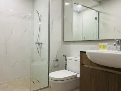 a bathroom with a shower and a toilet and a sink at Agile Signature Suites KL in Kuala Lumpur