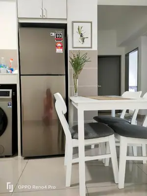 a kitchen with a white table and chairs and a refrigerator at M Centura Sentul Condominium Two Bedroom in Kuala Lumpur