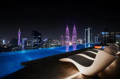 a white and black chair sitting on a rooftop at night at Atelier KLCC in Kuala Lumpur