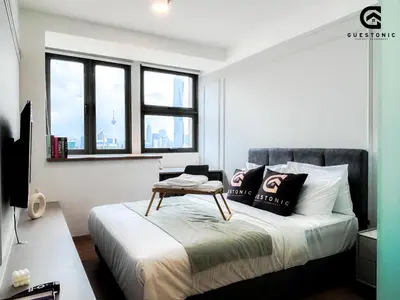 a bedroom with a bed with a table on it at Riveria City KL Sentral by Guestonic in Kuala Lumpur