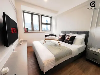 a bedroom with a bed with a table on it at Riveria City KL Sentral by Guestonic in Kuala Lumpur