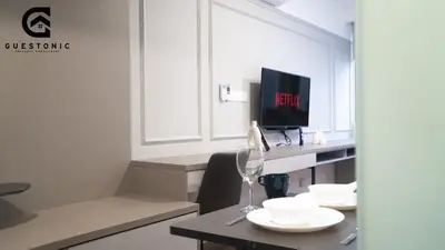 a room with a table with white plates and a tv at Riveria City KL Sentral by Guestonic in Kuala Lumpur