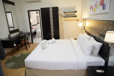 a bedroom with a large white bed and a bathroom at The Luxe Apartment 2 Bedrooms in Kuala Lumpur