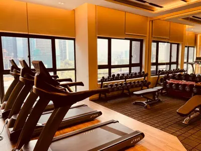 a gym with a row of chairs and a treadmill at Agile Premier Suites KL in Kuala Lumpur