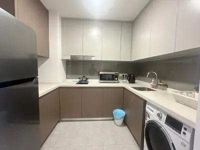 a kitchen with white cabinets and a washer and dryer at Agile Premier Suites KL in Kuala Lumpur