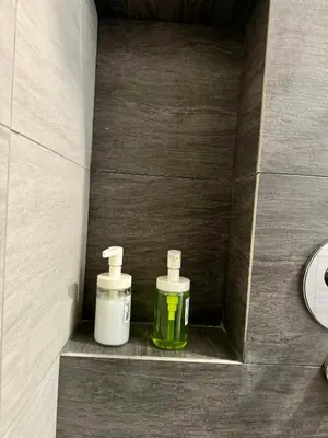 two bottles of soap sitting on a shelf in a bathroom at KLCC view appartment in Kuala Lumpur