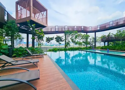 a swimming pool with chairs and a bridge over it at KLCC view appartment in Kuala Lumpur