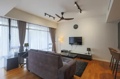 a living room with a couch and a tv at Anggun Residences Serviced Suites by GB in Kuala Lumpur