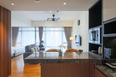 a living room with a kitchen and a living room with a couch at Anggun Residences Serviced Suites by GB in Kuala Lumpur