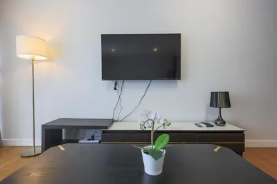 a living room with a tv and a table with a potted plant at Anggun Residences Serviced Suites by GB in Kuala Lumpur