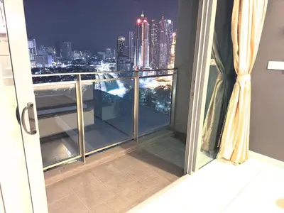 a balcony with a view of the city at night at Summer Suites klcc by kuala lumpur in Kuala Lumpur