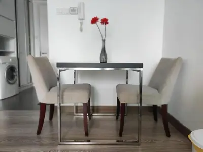 a table with two chairs and a vase with a flower on it at One Bukit Ceylon At Pavilion Bukit Bintang in Kuala Lumpur
