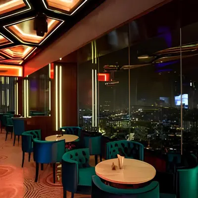 a restaurant with tables and chairs and a view of a city at Platinum 2 KLCC By Natol Chain Of Homestays in Kuala Lumpur