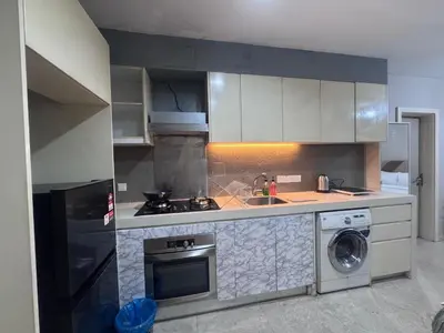 a kitchen with a stove and a washer and dryer at Bukit Bintang Fairlane KLCC suites by Angel in Kuala Lumpur