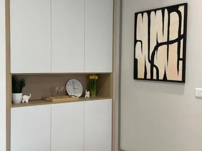 a kitchen with white cabinets and a clock on a shelf at Agile Bukit Bintang by Romeo Bnb in Kuala Lumpur