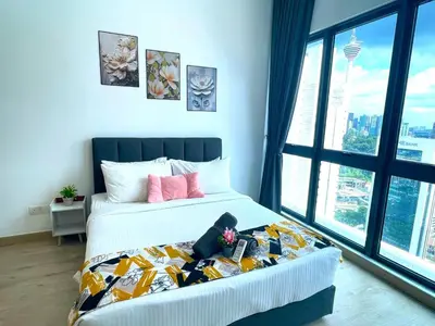 a bedroom with a bed with a blanket with pink pillows at Alaman Luxe suites KLCC in Kuala Lumpur