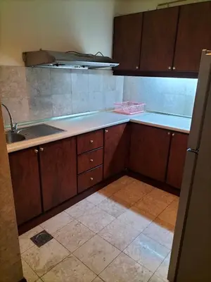 an empty kitchen with wooden cabinets and a sink at Times Square Suite KL in Kuala Lumpur