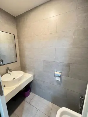 a bathroom with a sink and a toilet and a mirror at Arte Mont Kiara By Luxe Home in Kuala Lumpur
