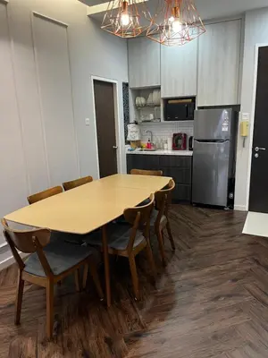a kitchen with a wooden table with chairs and a refrigerator at Seasons Gardens Wangsa Maju, KL - 3 bedroom apartment in Kuala Lumpur
