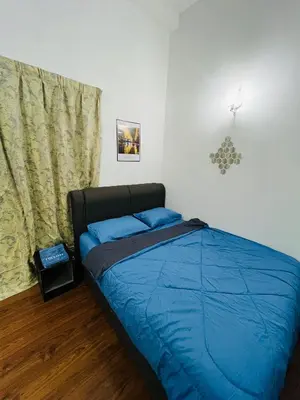 a bedroom with a bed with blue sheets and a window at VUE Residences Hkl Klcc view in Kuala Lumpur