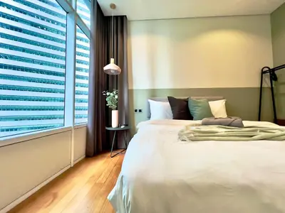 a bedroom with a bed and a large window at Sky Suites Chill 3BR Suite at KLCC in Kuala Lumpur