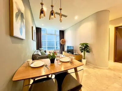 a living room with a dining room table with chairs at Sky Suites Chill 3BR Suite at KLCC in Kuala Lumpur