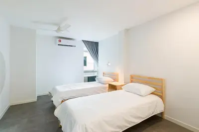 two beds in a room with white walls at Upstairs Downstairs CoLiving Kampung Pandan in Kuala Lumpur