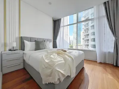 a bedroom with a white bed with a large window at Sky Suites Dreamy 3BR Suite at KLCC in Kuala Lumpur