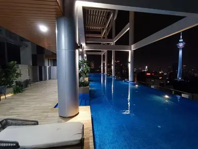 a large swimming pool on the roof of a building with a city skyline at COL 18A Modern Balcony KLCC View Infinity Pool in Kuala Lumpur