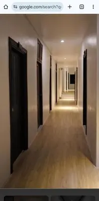 a hallway with a long corridor with black doors at Travel INN Bukitbintang in Kuala Lumpur