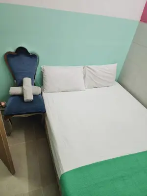 a bed and a blue chair in a room at Travel INN Bukitbintang in Kuala Lumpur