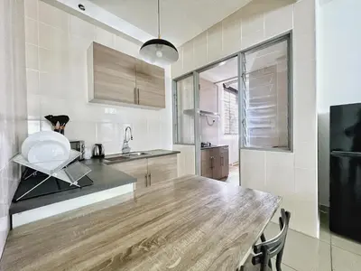 a kitchen with a large wooden table in a room at Rafflesia KL Big Family 3BR Condo Near LRT in Kuala Lumpur