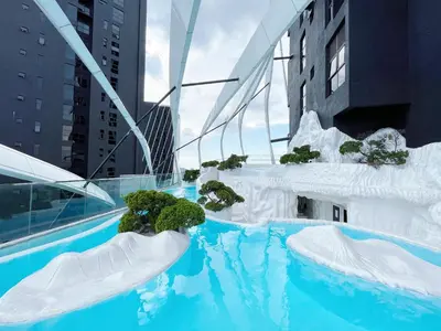 a swimming pool with icebergs and plants in a city at Arte mont kiara by Happy stay in Kuala Lumpur