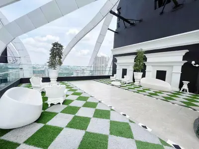a green and white checkered floor with white chairs on a building at Arte mont kiara by Happy stay in Kuala Lumpur