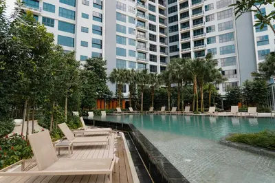 a swimming pool with lounge chairs in a building at Agile BB Residence Pavilion TRX by GB in Kuala Lumpur